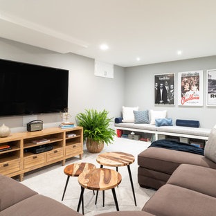 Home theater - transitional enclosed carpeted and beige floor home theater idea in Philadelphia with gray walls and a wall-mounted tv
