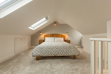 Example of a mid-sized carpeted and gray floor bedroom design in Surrey with beige walls