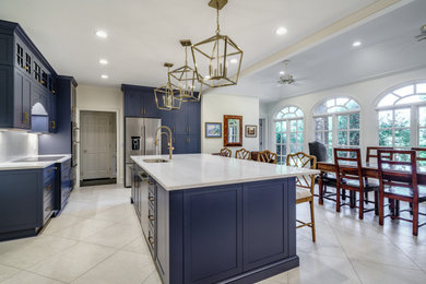 Huge transitional u-shaped porcelain tile and gray floor eat-in kitchen photo in Other with an undermount sink, shaker cabinets, blue cabinets, quartz countertops, white backsplash, quartz backsplash, stainless steel appliances, an island and white countertops