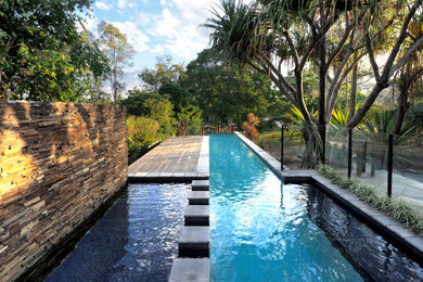 This is an example of a midcentury backyard rectangular lap pool in Brisbane with decking.