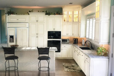 タンパにあるおしゃれなキッチン (レイズドパネル扉のキャビネット、白いキャビネット) の写真