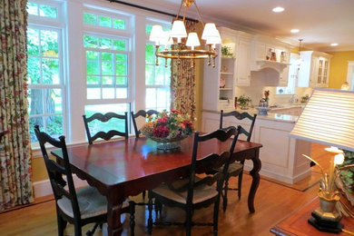 This is an example of a large transitional open plan dining in New York with yellow walls, medium hardwood floors and no fireplace.