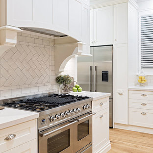 Large traditional kitchen pantry remodeling - Kitchen pantry - large traditional galley kitchen pantry idea in Hobart with a farmhouse sink, shaker cabinets, white cabinets, granite countertops, white backsplash, porcelain backsplash, stainless steel appliances, an island and white countertops