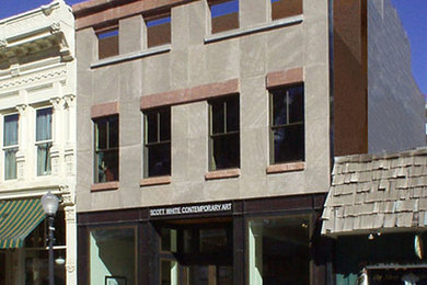 Ejemplo de fachada gris actual pequeña de tres plantas con revestimiento de piedra