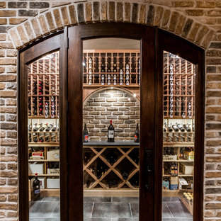Exempel på en stor klassisk vinkällare, med klinkergolv i keramik och vinhyllor