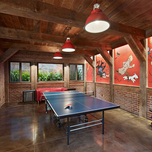 This is an example of an eclectic look-out basement in San Francisco with concrete flooring, multi-coloured walls, no fireplace and brown floors.