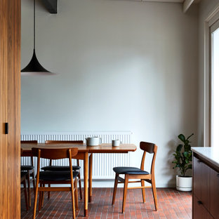 Ejemplo de comedor retro, de tamaño medio, con suelo de ladrillo y suelo rojo