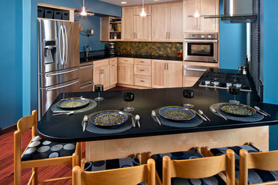 Inspiration for a large contemporary l-shaped medium tone wood floor eat-in kitchen remodel in Omaha with shaker cabinets, light wood cabinets, stone tile backsplash, stainless steel appliances, a peninsula, granite countertops, multicolored backsplash and an undermount sink