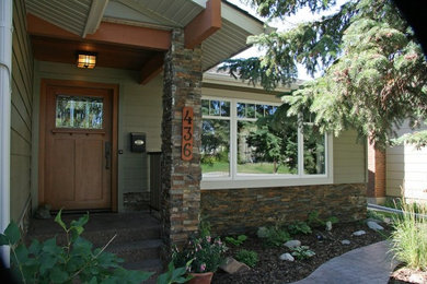 Photo of a large traditional one-storey green exterior in Calgary with wood siding.