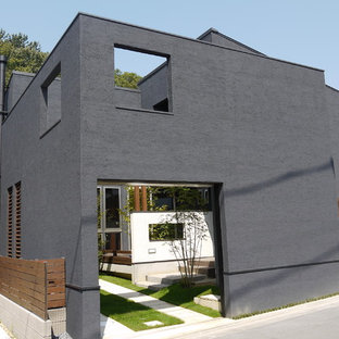 Modern inredning av ett mellanstort grått hus, med två våningar, stuckatur, sadeltak och tak i metall