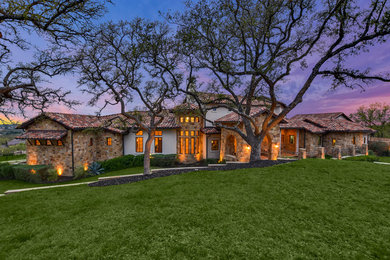Inspiration for a large mediterranean multicolored two-story mixed siding exterior home remodel in Austin with a tile roof
