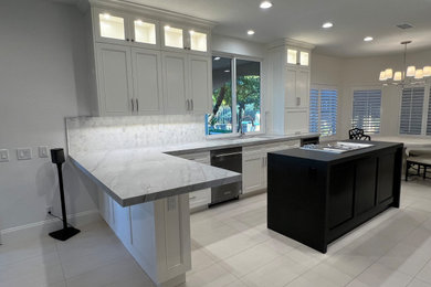 Kitchen - large kitchen idea in Orange County with white cabinets, quartzite countertops and an island