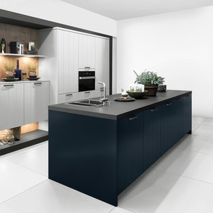 Mid-sized transitional kitchen pantry designs - Inspiration for a mid-sized transitional galley kitchen pantry remodel in Christchurch with a drop-in sink, recessed-panel cabinets, white cabinets, laminate countertops, stainless steel appliances and an island