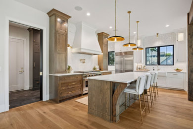Kitchen - large transitional medium tone wood floor kitchen idea in Minneapolis with a farmhouse sink, quartz countertops, white backsplash, quartz backsplash, stainless steel appliances, an island and white countertops