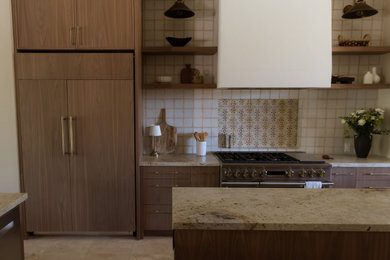 Mid-sized transitional ceramic tile and beige floor kitchen photo in Phoenix with a farmhouse sink, shaker cabinets, beige cabinets, granite countertops, terra-cotta backsplash, paneled appliances and two islands