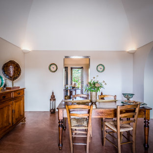 Idee per una sala da pranzo mediterranea con pareti grigie, pavimento in cemento, pavimento marrone e soffitto a volta