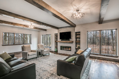 Inspiration for a transitional open concept medium tone wood floor and brown floor living room remodel in Milwaukee with gray walls, a standard fireplace, a stone fireplace and a wall-mounted tv