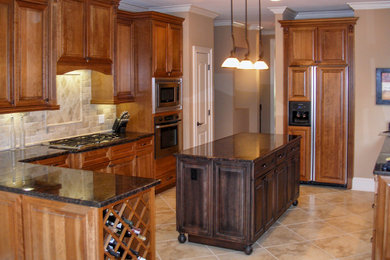 Mid-sized elegant u-shaped porcelain tile eat-in kitchen photo in Charlotte with an undermount sink, raised-panel cabinets, medium tone wood cabinets, granite countertops, beige backsplash, stone tile backsplash and stainless steel appliances