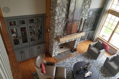 Example of a mid-sized mountain style enclosed and formal light wood floor living room design in Other with white walls, a standard fireplace, a stone fireplace and no tv