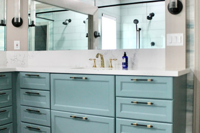 Large transitional master blue tile and porcelain tile porcelain tile, gray floor, double-sink and wallpaper bathroom photo in Houston with recessed-panel cabinets, blue cabinets, a two-piece toilet, an undermount sink, quartz countertops, a hinged shower door, white countertops and a built-in vanity