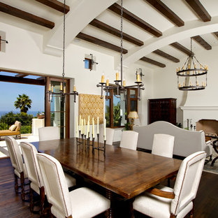 サンディエゴの中サイズの地中海スタイルのLDKの画像 (白い壁、濃色無垢フローリング、標準型暖炉、漆喰の暖炉まわり、茶色い床)