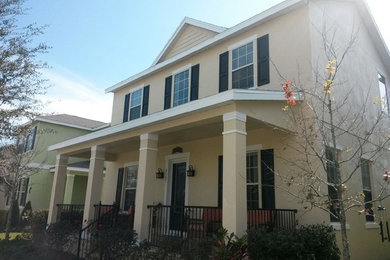Inspiration for a mid-sized yellow two-story stucco gable roof remodel in Tampa