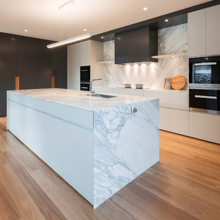 Large contemporary kitchen pantry ideas - Large trendy galley light wood floor kitchen pantry photo in Canberra - Queanbeyan with an undermount sink, marble countertops, white backsplash, stainless steel appliances and an island