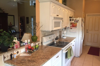 Tuscan single-wall ceramic tile eat-in kitchen photo in Miami with an undermount sink, raised-panel cabinets, white cabinets, granite countertops, beige backsplash, stone tile backsplash and stainless steel appliances