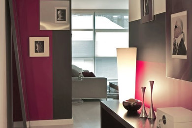 Photo of a small contemporary entry hall in New York with multi-coloured walls and light hardwood floors.