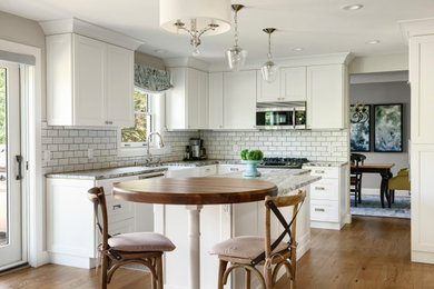 Inspiration för ett litet vintage vit vitt l-kök, med en rustik diskho, skåp i shakerstil, vita skåp, marmorbänkskiva, vitt stänkskydd, stänkskydd i tunnelbanekakel, rostfria vitvaror, mellanmörkt trägolv, en köksö och brunt golv