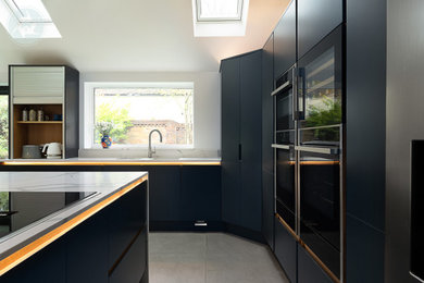This is an example of a large contemporary l-shaped open plan kitchen in Berkshire with a built-in sink, marble worktops, cement flooring, an island and grey floors.