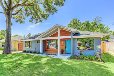 Inspiration for a mid-century modern gray concrete fiberboard exterior home remodel in Houston with a shingle roof