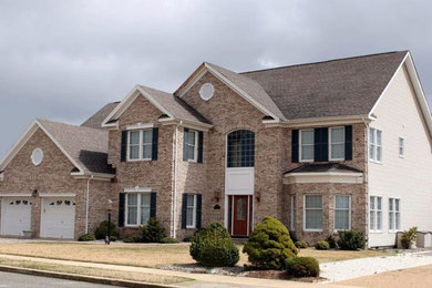 Inspiration for a mid-sized timeless beige two-story mixed siding exterior home remodel in DC Metro with a shingle roof