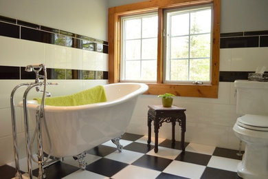 Imagen de cuarto de baño tradicional con bañera con patas, sanitario de dos piezas, baldosas y/o azulejos blancas y negros, baldosas y/o azulejos de cerámica, paredes grises y suelo de baldosas de cerámica