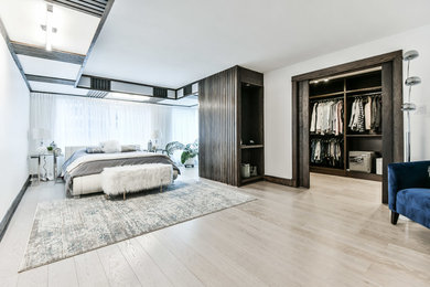 Example of a large trendy master light wood floor and beige floor bedroom design in Toronto with beige walls and no fireplace