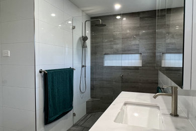 Inspiration for a mid-sized modern master bathroom in Sydney with recessed-panel cabinets, white cabinets, an open shower, a one-piece toilet, white tile, ceramic tile, white walls, porcelain floors, a drop-in sink, marble benchtops, grey floor, an open shower, white benchtops, a niche and a floating vanity.