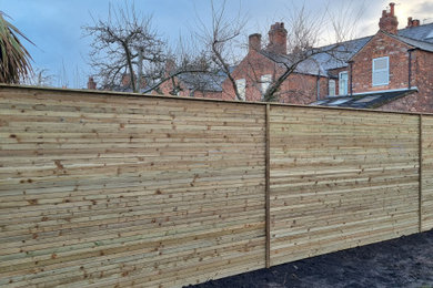 Immagine di un giardino design dietro casa con recinzione in legno