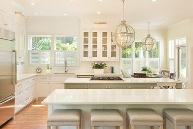 Inspiration for a large timeless u-shaped medium tone wood floor and brown floor eat-in kitchen remodel in Portland with an undermount sink, recessed-panel cabinets, white cabinets, subway tile backsplash, stainless steel appliances, an island, quartz countertops and white backsplash