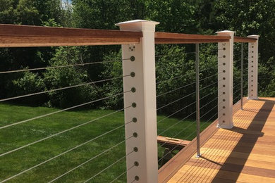 Mahogany deck, with FEENEY cable rails, stone patio underneath, and Pergola top