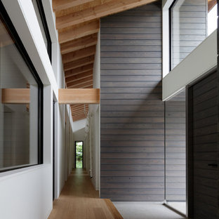 Idee per un ingresso o corridoio moderno con pavimento in compensato, una porta a due ante, una porta grigia e pavimento marrone