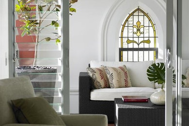 This is an example of a mid-sized enclosed living room in Sydney with white walls and medium hardwood floors.