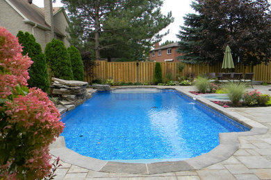 Inspiration for a mid-sized transitional backyard concrete paver and rectangular hot tub remodel in Toronto
