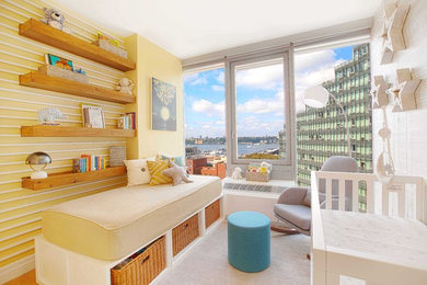 Nursery - small contemporary gender-neutral light wood floor and brown floor nursery idea in New York with gray walls