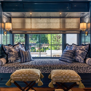 Foto de biblioteca en casa abierta, mediterránea, grande, sin televisor, con paredes azules, suelo de madera oscura, chimenea tradicional, marco de chimenea de piedra y suelo marrón