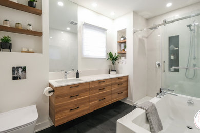 Idéer för mellanstora nordiska vitt en-suite badrum, med släta luckor, skåp i mellenmörkt trä, ett badkar i en alkov, en dusch i en alkov, en vägghängd toalettstol, vit kakel, keramikplattor, vita väggar, klinkergolv i keramik, ett undermonterad handfat, bänkskiva i kvarts, svart golv och dusch med skjutdörr