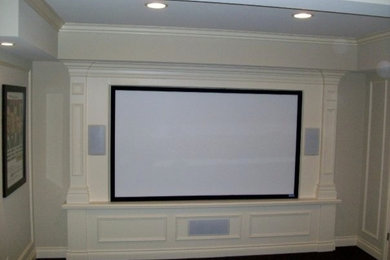 Imagen de cine en casa cerrado de tamaño medio con pantalla de proyección, paredes blancas y moqueta