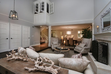 Example of a large classic open concept dark wood floor living room design in Orange County with gray walls, a standard fireplace and a stone fireplace