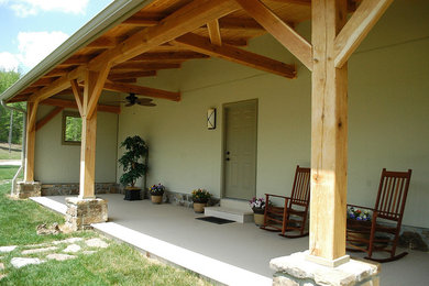 Large arts and crafts concrete back porch idea in Nashville with a roof extension