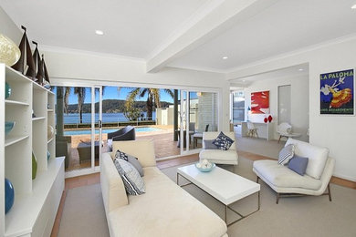 Photo of a mid-sized beach style open concept family room in Sydney with white walls, terra-cotta floors, no fireplace, no tv and red floor.