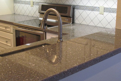 Eat-in kitchen - mid-sized modern l-shaped eat-in kitchen idea in San Francisco with an undermount sink, quartz countertops, white backsplash, ceramic backsplash, stainless steel appliances, no island, recessed-panel cabinets and white cabinets